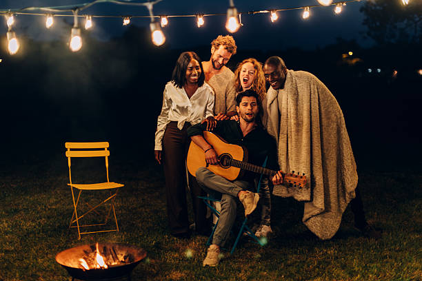 istock Friends enjoying music and campfire at night 2201859514