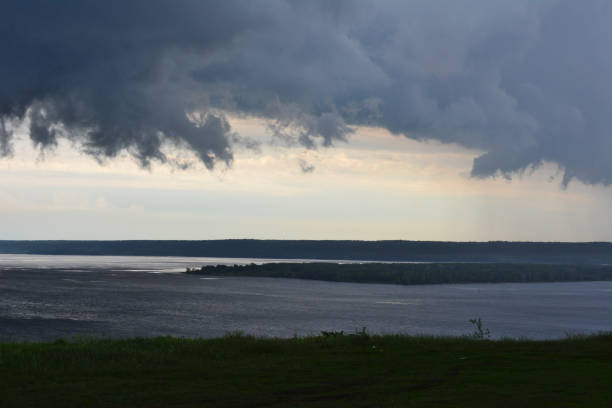 a stormy and dark cloud over the hill and the river