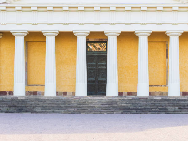 The striking building at Uppsala Botanical Garden showcases impressive columns and a beautifully crafted entrance, inviting visitors to explore its rich history and serene surroundings.
