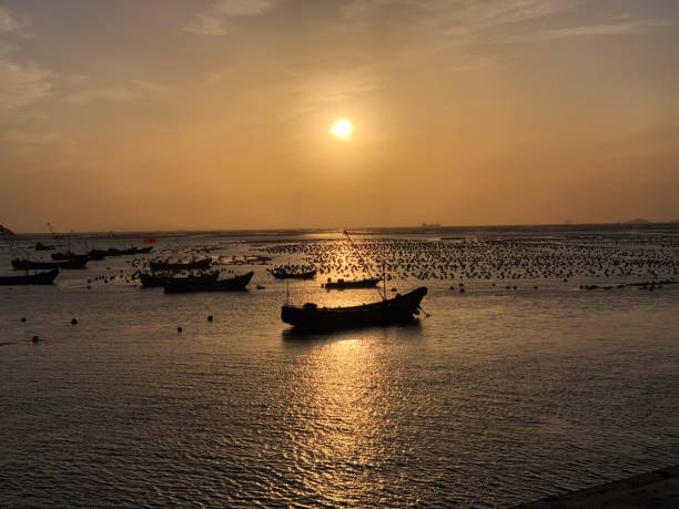 istock Sunset Over Tranquil Sea with Boats 2201862339