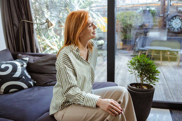 istock Woman relaxing on a couch with sunlight through the large window 2201862621