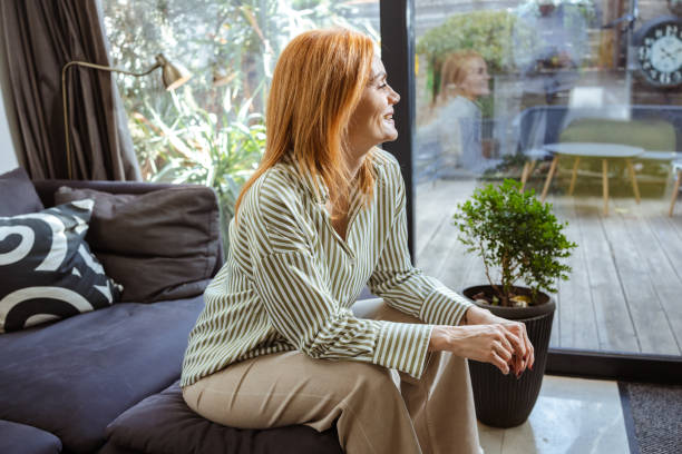 istock Woman sitting on a couch in a bright and modern living space 2201862623