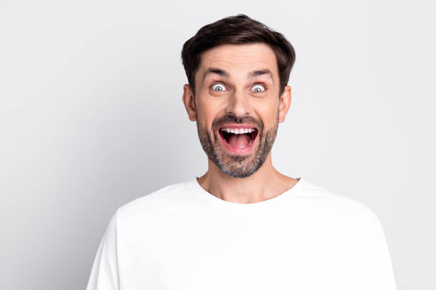 istock Excited Male Model Expressing Joy with Open Mouth and Wide Eyes on a Minimal Grey Background 2201864220