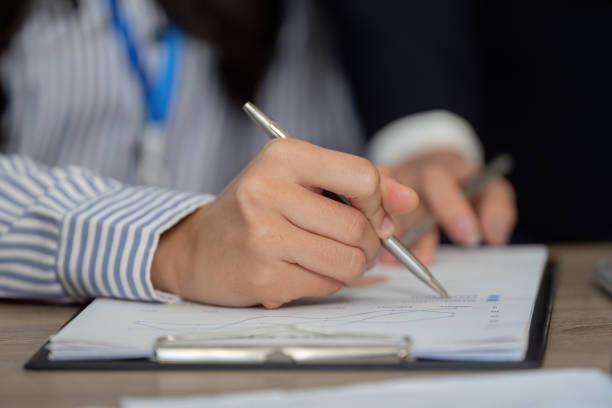 istock Close-up of hands analyzing financial data, focusing on calculations and strategies. 2201864676