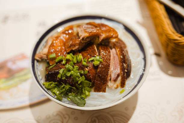 Dry egg noodles with roasted duck, a classic Chinese noodle dish.