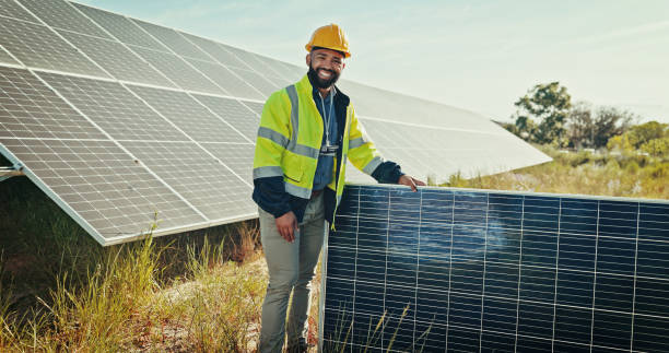 istock Happy man, portrait and solar panel at farm, energy saving and supervisor for maintenance service. Male person, renewable power supply and outdoor for ecology project, safety helmet and grid field 2201865258