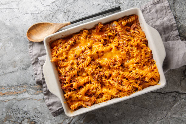 Hot spicy sloppy joe casserole with beef, pasta, vegetables and sauce and lots of cheese close-up in baking dish on table. Horizontal top view stock photo