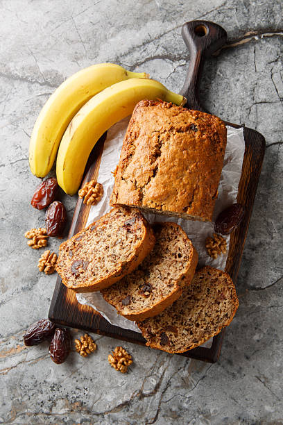 istock Date banana nuts diet bread close-up on wooden board. Vertical top view 2201866755