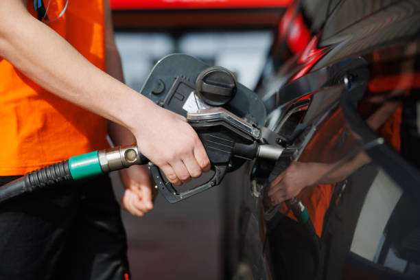 istock Hand holding gasoline nozzle and refueling 2201867639