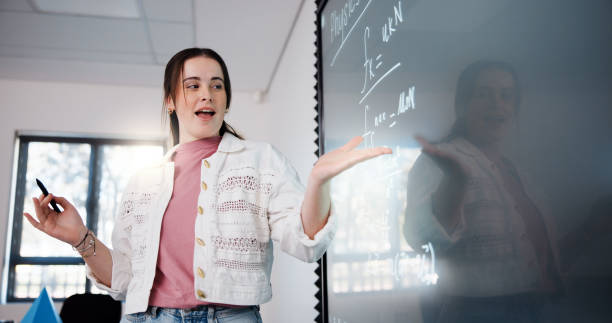 istock Education, woman and student by board in classroom explaining science equation at college. Revision, lecture and female person writing physics research for university exam, test or assignment. 2201869871