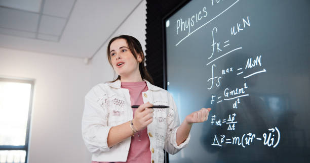istock Education, woman and student by board in lecture explaining science equation to class at college. Revision, writing and female person with physics research for university exam, test or assignment. 2201869873