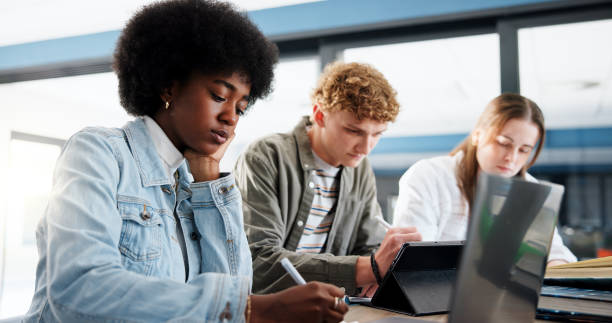 istock Research, group and students with laptop, classroom and studying for assignment in college or writing. Education, learning and people with tech for knowledge, university and teamwork for project 2201869895