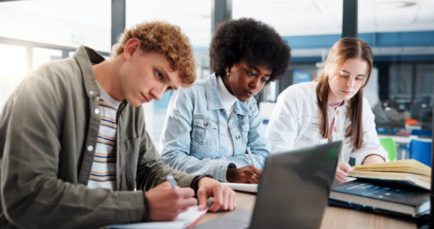 istock Learning, group and students with laptop, classroom and research for assignment in college or writing. Education, studying and people with tech for knowledge, university and teamwork for project 2201869896