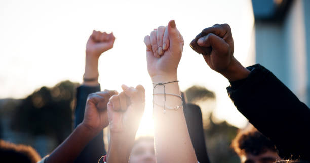 Hands, fist and students with protest outdoor for education riot, university equality and change law. Group, people and power with call to action for free learning, society support and racism justice