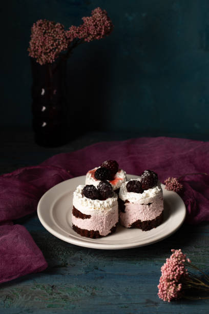 istock Delicious cream cakes with blackberries on a plate. Still life in a rustic style 2201870896