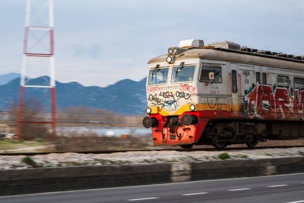 Virpazar, Montenegro – February 16, 2025: The Montenegrin train on the road Podgorica-Bar on a sunny day with mountainous background