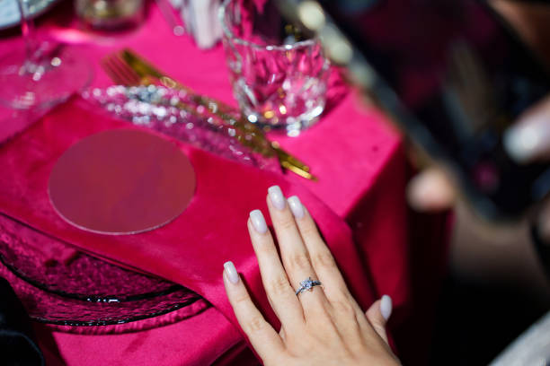 istock A woman's hand with a new ring. the background of a table with a red tablecloth 2201871906