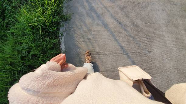 A girl walks down the cement ground street, beautiful weather sunlight casting tree shadows sway with my steps. lovely afternoon, viewed from above, taking a selfie, my feet, human legs, foot, shoes