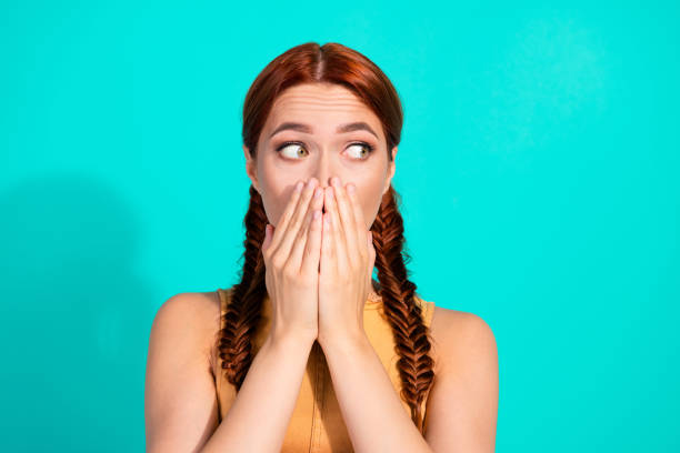 istock Young red-haired woman with playful expression gesturing surprise on a vibrant turquoise background 2201874437