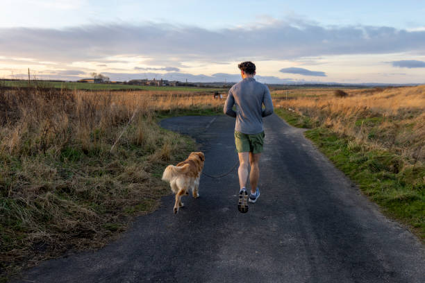Man and his Dog Running in the Countryside