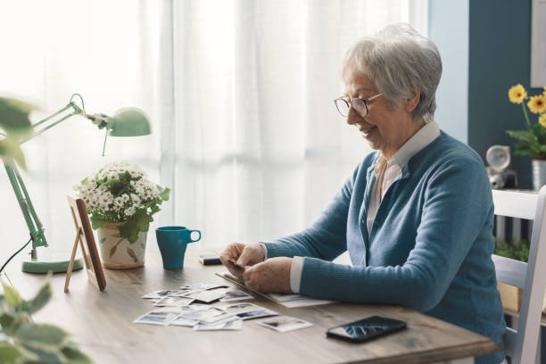 istock Happy senior lady going through old pictures 2201877327