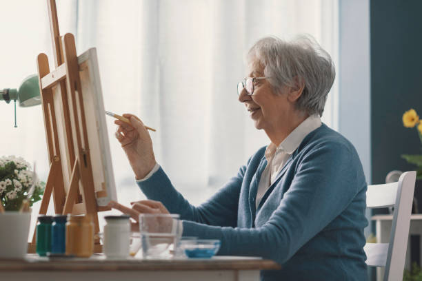 istock Senior woman painting on canvas 2201877420