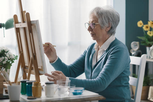 istock Senior woman painting on canvas 2201877434