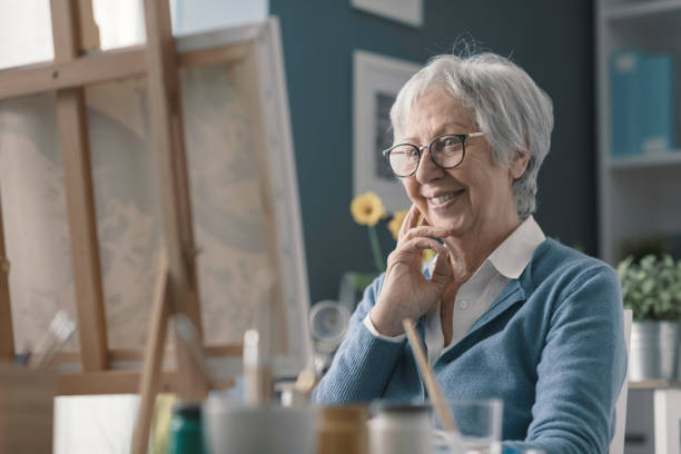istock Happy senior lady looking at her finished artwork 2201877537