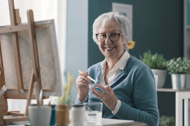 istock Smiling senior artist posing in her studio 2201877566