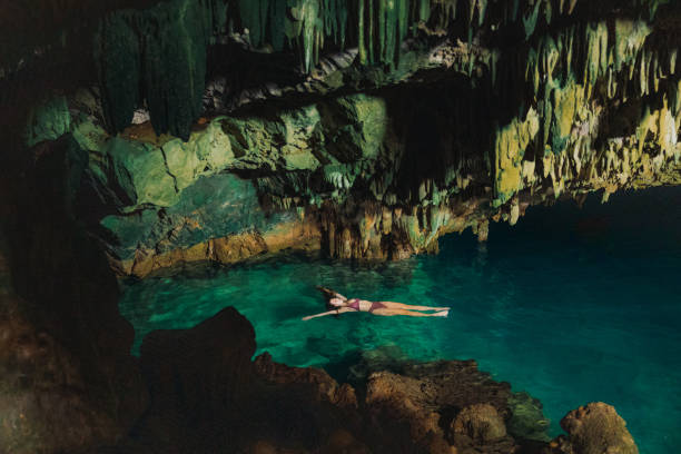 istock Happy Traveller Floating in Majestic Hidden Cave on Crystal Blue Water 2201881685