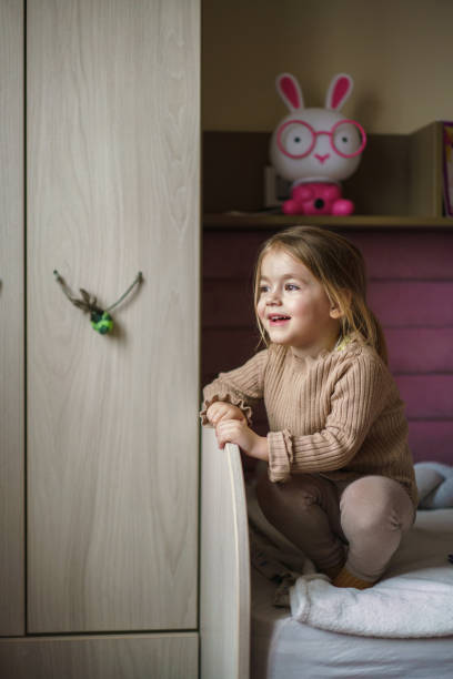 istock Little girl sitting on her bed 2201882011