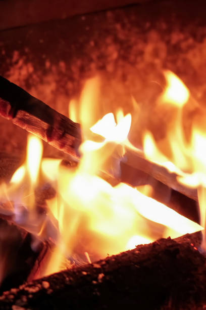 POKHARA, NEPAL - JANUARY 7, 2025: Warmth of a bonfire on a evening in Pokhara, Nepal, surrounded by a tranquil ambiance and glowing color, close up handheld shot, vertical.