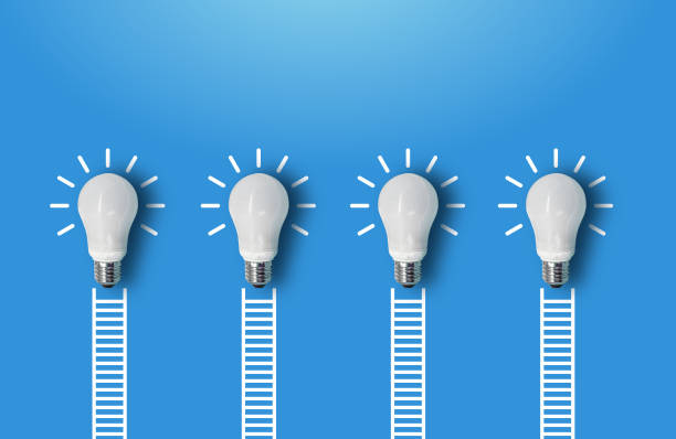 istock White Ladders and Lightbulbs in a Row Leaning on Blue Wall. 2201883233