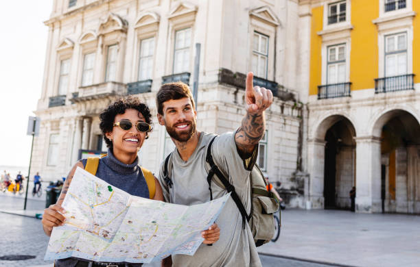 istock Happy tourists couple exploring lisbon using map and pointing finger 2201884524