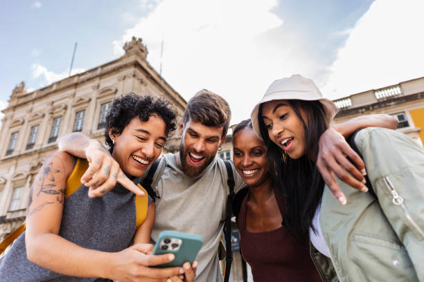 istock Group of tourists laughing while looking at smartphone in lisbon 2201884631