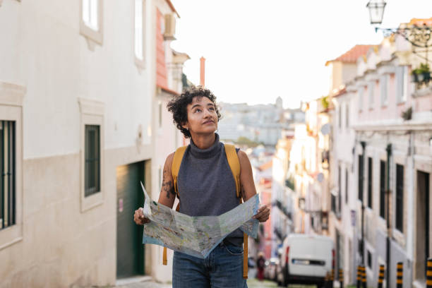 istock Young tourist exploring lisbon with map in hand, looking up 2201885894