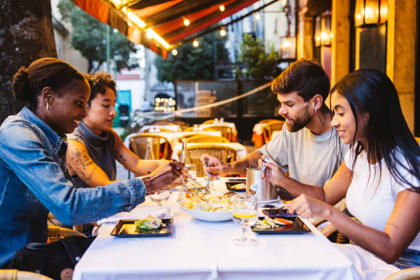istock Young friends enjoying dinner at a restaurant in lisbon 2201886030