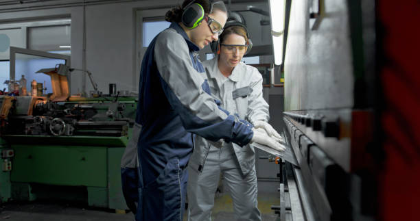 istock Female Technicians Operating Metal Press Brake in Industrial Workshop Environment 2201887448