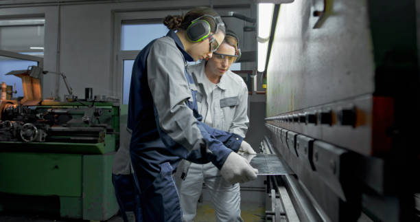 istock Female Technicians Operating Metal Press Brake in Industrial Workshop 2201887509