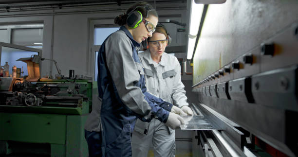 istock Female Technicians Operating Metal Press Brake in Industrial Factory 2201887521