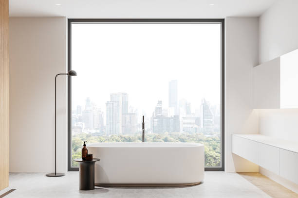 istock Minimalist bathroom with freestanding tub and large window overlooking cityscape. 3D Rendering 2201888257