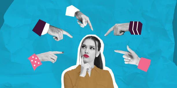 istock Thoughtful woman surrounded by pointing hands on blue background 2201888311