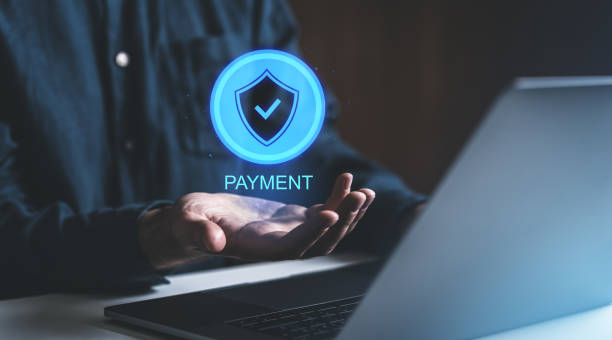 istock Digital payment security concept with shield icon hovering over a hand near laptop. 2201888410