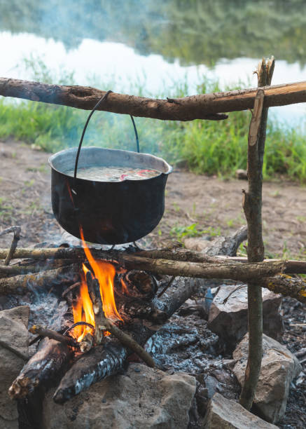 istock Cooking a fish soup in a pot on a fire on the river bank 2201888735
