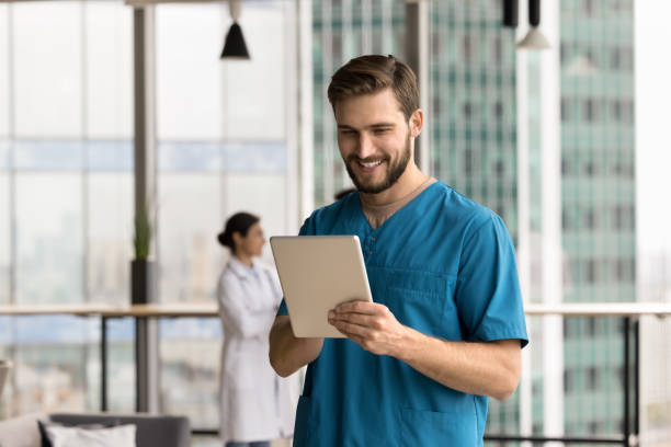 istock Young medical worker wear blue scrubs using tablet in clinic 2201889198