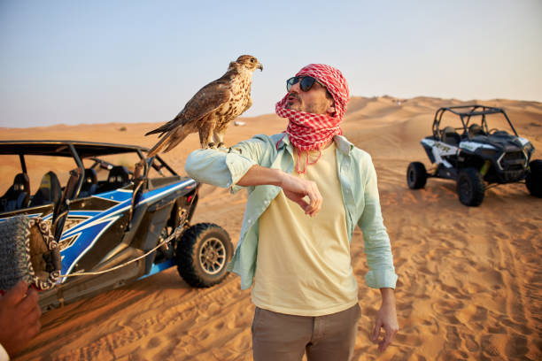 istock Handsome man holding falcon in Dubai desert 2201890697