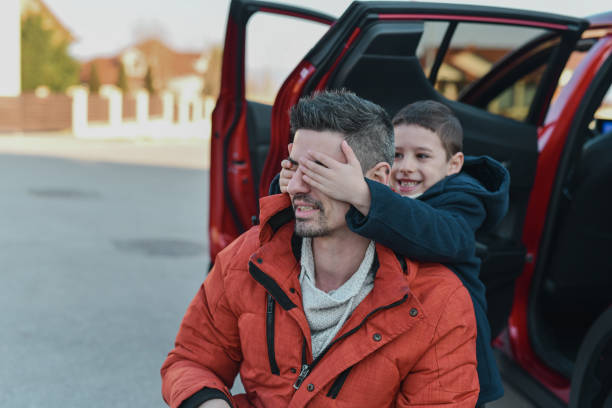 istock Son Closing Father's Eyes Preparing Surprise For Him With His Mom 2201891884