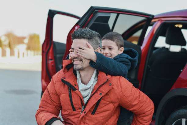 istock Joyful Boy Preparing Surprise For Father Closing His Eyes While He's Waiting With Anticipation 2201891959