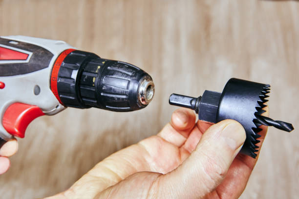 istock Cordless drill aligning with a door lock hole saw attachment and drill bit, ready for precise woodworking. 2201896583