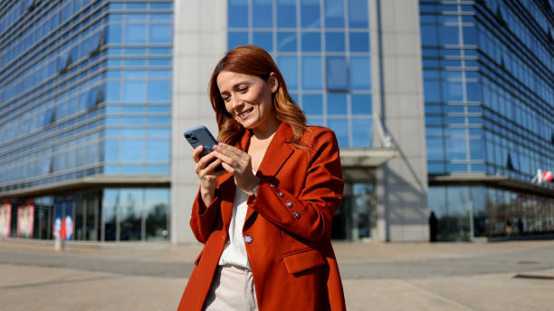 istock A stunning woman texting on her smartphone while walking through the city 2201899086